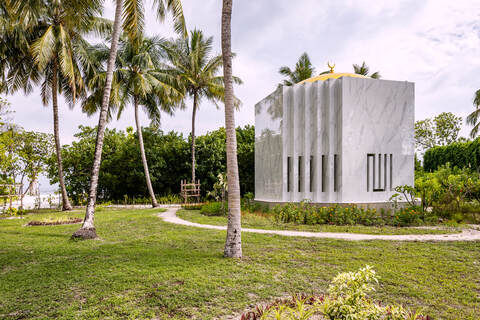 Mosque nestled between palm trees at a beach resort