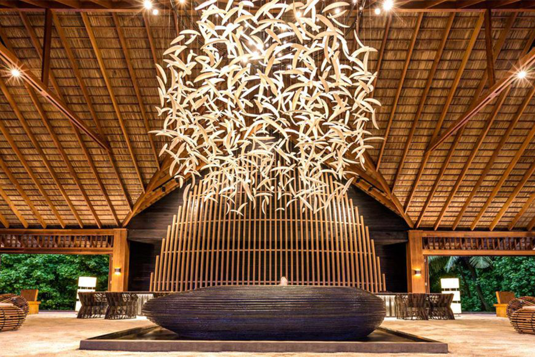 Luxury Maldives resort lobby with a feature chandelier and natural design elements like wood work