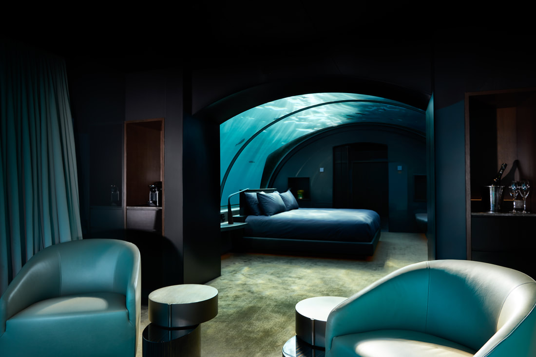 Nighttime in the contemporary aquarium bedroom of the under water villa at a luxury resort in the Maldives