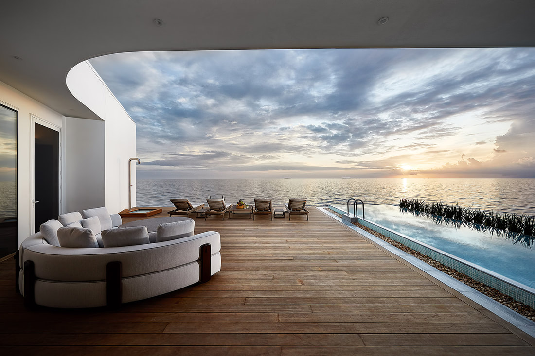 Looking out to the ocean at sunset from the deck of the luxury villa. An infinity pool is on the right with lounge chairs on the left
