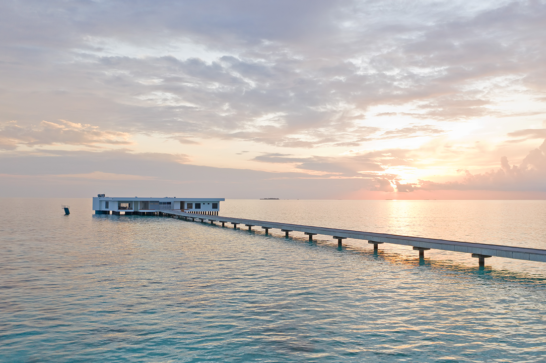 sunset over the Indian ocean in the Maldives a unique over water villa suite stands on stilts 