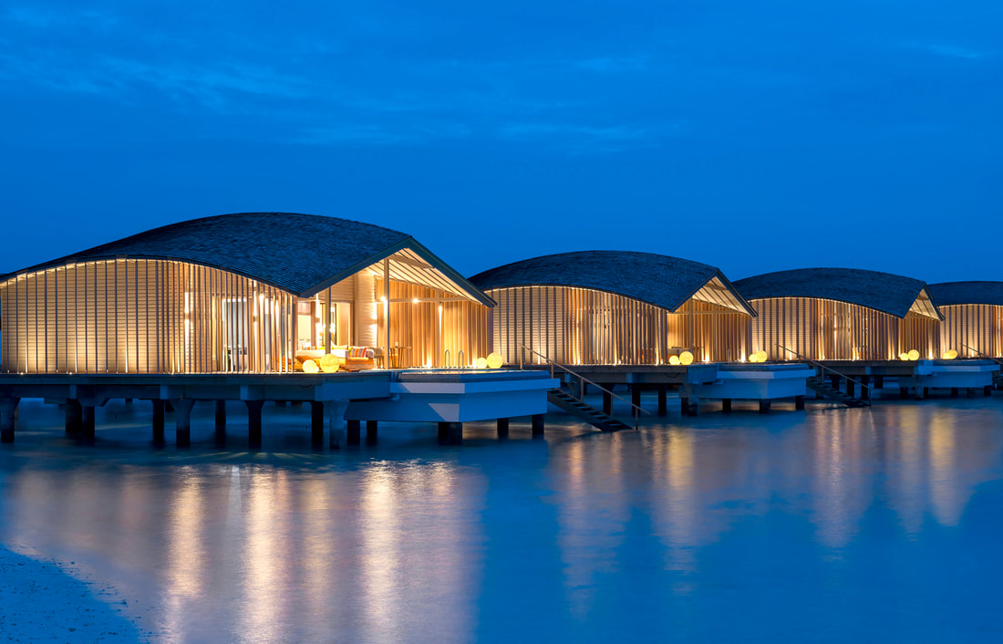 Over water luxury villas at night curved architecture 